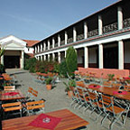 Die Terrasse mit Tischen auf dem sonnigen Innenhof der römischen Herberge.