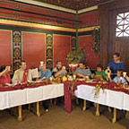 Besucherinnen und Besucher speisen im Restaurant der römischen Herberge.
