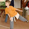 In het Romeinse speelhuis probeert een jongen het amfora-gooispel terwijl een paar volwassenen toekijken.