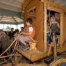 Einige Kinder erkunden eine rekonstruierte römische Kutsche.