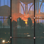 Een weerspiegeling van de zonsondergang in de glazen gevel van de overkapping.