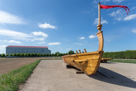 Das Segelschiff Minerva Tritonia auf einer Kiesfläche vor dem Römermuseum